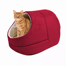 An orange tabby cat sitting inside a Pets Paradise Elite Warming Burrow Suede Cat Cave Bed with a cave-like design.